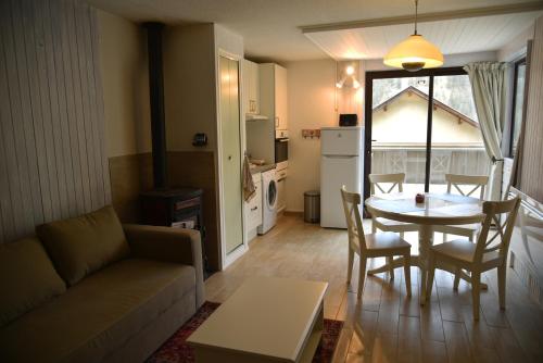 ein Wohnzimmer mit einem Sofa und einem Tisch in der Unterkunft Appartement lumineux et calme - La Foux-Mercantour in Allos