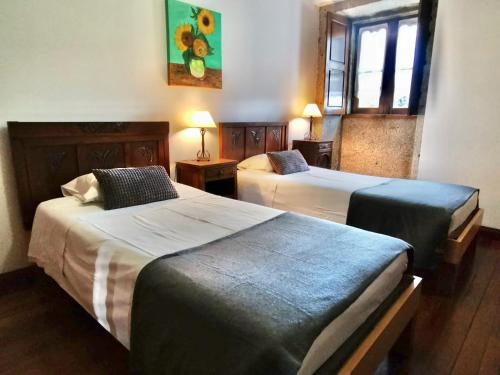 una camera d'albergo con due letti e una finestra di Casa do Faial - Braga a Braga