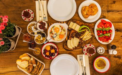 una mesa de madera cubierta con platos y tazones de comida en Cunda Battalos Kucuk Hotel, en Ayvalık