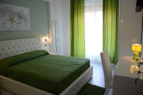 a bedroom with a green bed and a table and a window at B&B Crystal in Messina