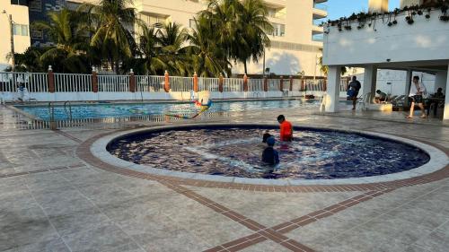 dwójka dzieci bawiących się w fontannie w centrum handlowym w obiekcie Ayenda Soft Vanilla House Boutique w mieście Cartagena de Indias