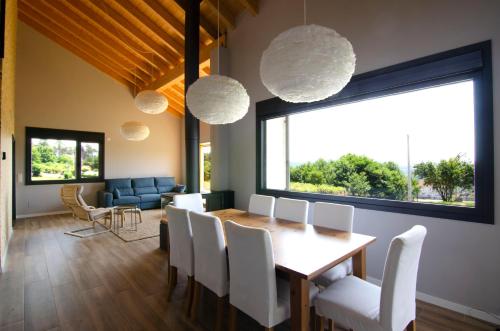 uma sala de jantar com uma mesa e cadeiras brancas em Espectacular casa con encanto para familias y grupos em Ourense