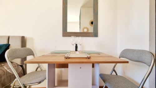 une table de salle à manger avec deux chaises et un miroir dans l'établissement Le City View - Calme - Moderne - Balcon - RelaxBNB, à Illzach