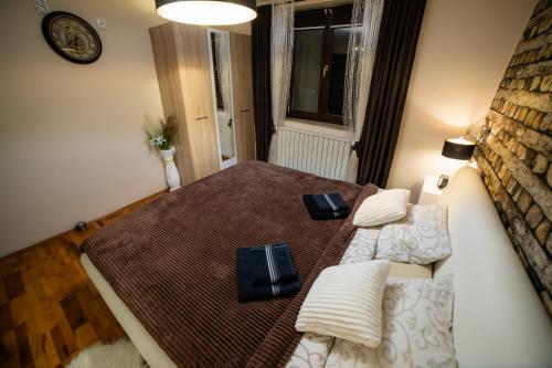 a bedroom with a bed and a couch and a window at Vila Jezerski raj Borsko jezero in Bor