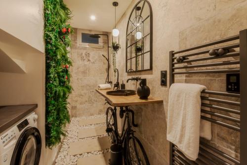 un baño con una bicicleta estacionada junto a un fregadero en L'improbable raffiné, élégant et chaleureux, 