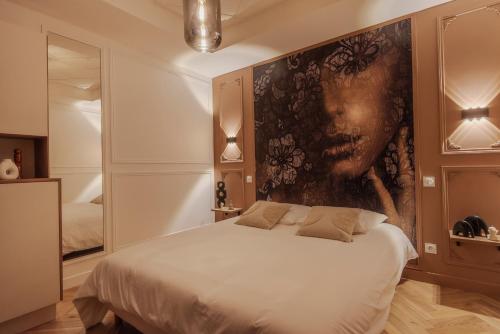 1 dormitorio con 1 cama con una pintura en la pared en L'improbable raffiné, élégant et chaleureux, 