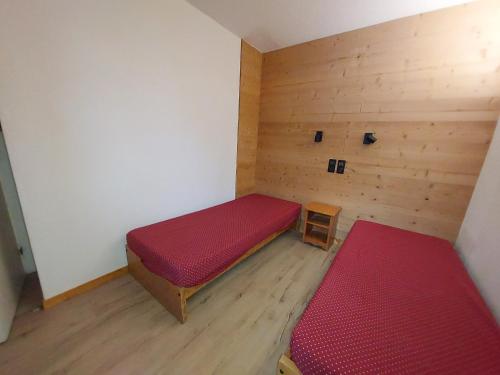 ヴァルモレルにあるAppartement Valmorel, 2 pièces, 5 personnes - FR-1-356-196の赤いベッドとテーブルが備わる小さな客室です。