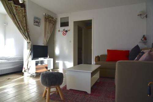 ein Wohnzimmer mit einem Sofa und einem Tisch in der Unterkunft Appartement lumineux et calme - La Foux-Mercantour in Allos