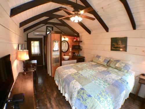 1 dormitorio con 1 cama y ventilador de techo en Tiny Home Cottage Near the Smokies #10 Helena, en Sevierville