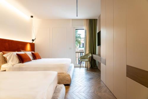 une chambre d'hôtel avec deux lits et un canapé dans l'établissement Donna Giacinta Luxury Accomodation, à Bari