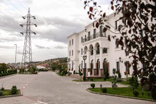 Un edificio bianco con un palo di potenza davanti di Hotel Beli Dvor a Čačak
