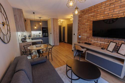 - un salon avec un canapé et un mur en briques dans l'établissement Apartamenty DeLux Centrum Kielce, à Kielce