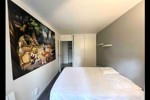 a bedroom with a large painting on the wall at Suite Rêve Étoilé, Disneyland Paris, 6 personnes in Serris