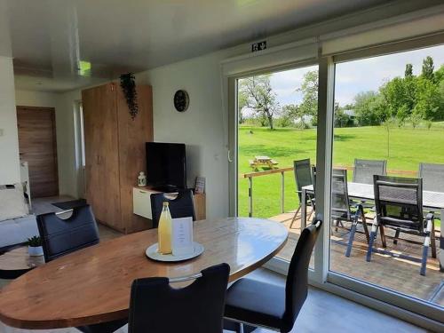 a living room with a table and a sliding glass door at Hoeve Terwinghe in Gingelom
