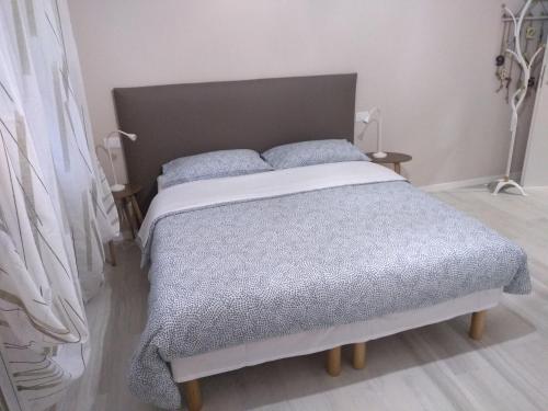 una camera da letto con un letto con un piumone grigio e due lampade di Casa Cavour a Osio Sotto