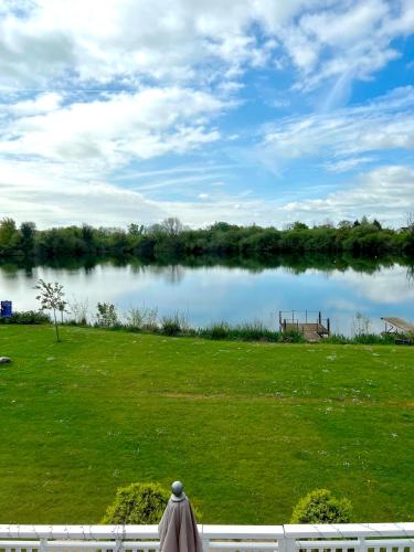 a view of a lake from a yard at The Cotswolds Lakeside - Kinsale Lodge,Spring Lake in South Cerney