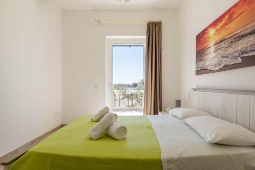 Schlafzimmer mit einem großen Bett und einem Fenster in der Unterkunft Casa D'Amare in Ostuni Costa Merlata