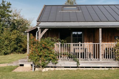 a wooden house with a porch and a balcony at Retreat East in Ipswich