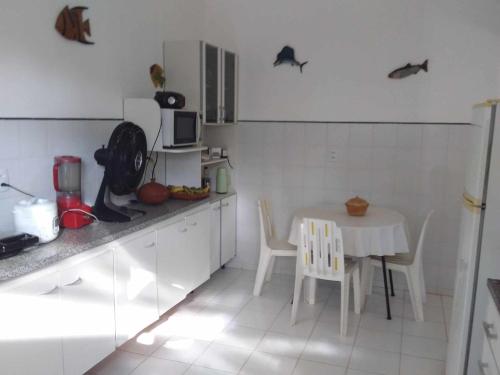 eine Küche mit einem Tisch und einem Tisch und Stühlen in der Unterkunft Casa de Praia Itacimirim Bahia in Camassari
