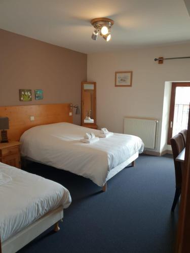 a hotel room with two beds and a window at Auberge Communale de la Fruitière in Péron