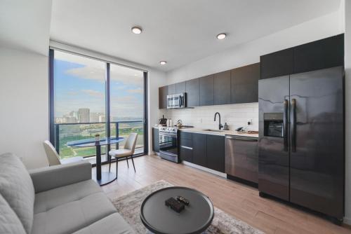 een keuken en een woonkamer met een bank en een tafel bij Charming Studio Apartment in an Exclusive Oasis in Miami