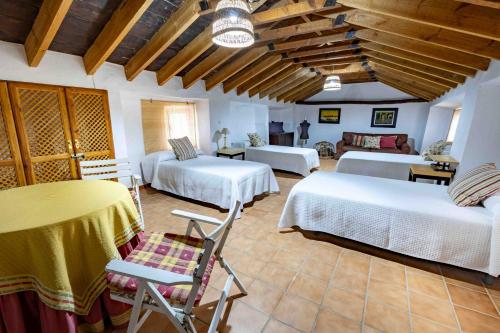 a room with two beds and a table and chairs at Molino de Gris Cazorla in Chilluévar