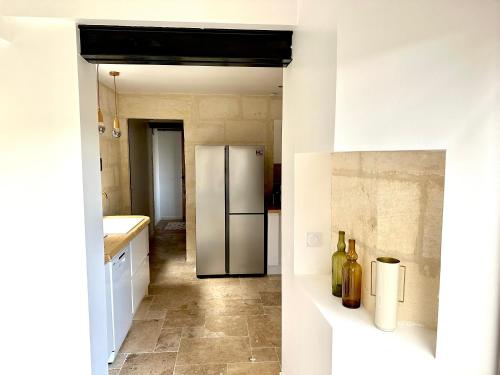 a kitchen with a stainless steel refrigerator at Charmante Maison La Libournaise +parking in Libourne