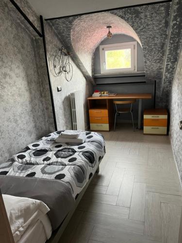 una camera con letto, scrivania e finestra di Blackheart casa vacanze a Pellezzano
