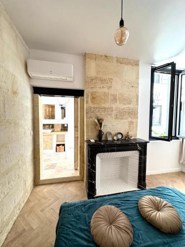 une chambre avec une cheminée et un lit bleu dans l'établissement Charmante Maison La Libournaise +parking, à Libourne