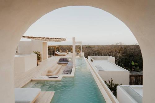 an archway over a swimming pool in a house at Villa Viento 4br 8pp Private Pool Rooftop Security in Tulum