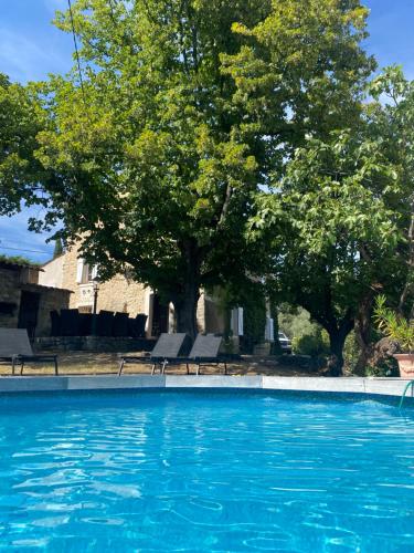 uma piscina com cadeiras e árvores ao fundo em Villa Mas de la Roche em Fayence