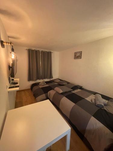 a room with two beds and a table in it at T2D Apartment - Suite BLG proche Disneyland Paris in Bussy-Saint-Georges