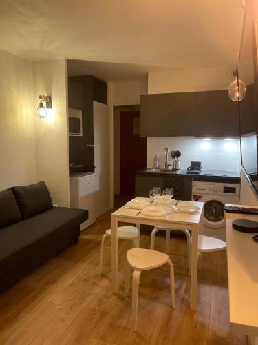 une cuisine et un salon avec une table et un canapé dans l'établissement T2D Apartment - Suite BLG proche Disneyland Paris, à Bussy-Saint-Georges