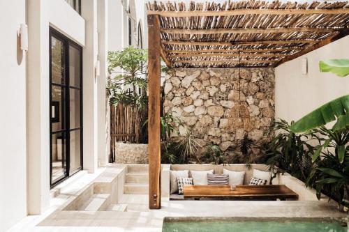 a patio with a bench and a stone wall at Villa Viento 4br 8pp Private Pool Rooftop Security in Tulum