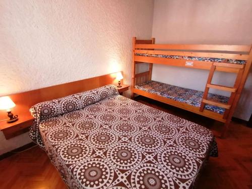 a bedroom with a bed and a bunk bed at Appartement Le Grand-Bornand, 1 pièce, 5 personnes - FR-1-241-202 in Le Grand-Bornand