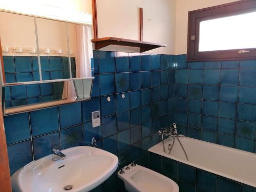 a blue tiled bathroom with a sink and a tub at Appartement Le Grand-Bornand, 1 pièce, 5 personnes - FR-1-241-202 in Le Grand-Bornand