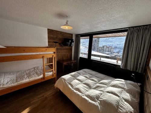 une chambre avec un lit et une grande fenêtre dans l'établissement Appartement au pied des pistes pour 4 pers, balcon sud, centre des Menuires, proche commerces - FR-1-452-184, aux Menuires