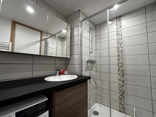 une salle de bain avec un lavabo et un miroir dans l'établissement Appartement au pied des pistes pour 4 pers, balcon sud, centre des Menuires, proche commerces - FR-1-452-184, aux Menuires