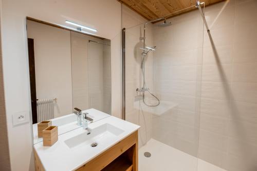 a white bathroom with a sink and a shower at Maison Salina in Samoëns