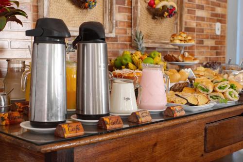 un buffet de comida con dos teteras en una mesa en Hotel Girassol da Serra, en Santa Maria Madalena