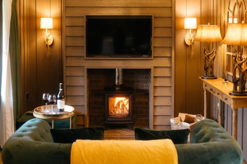 a living room with a fireplace and a tv at Retreat East in Ipswich