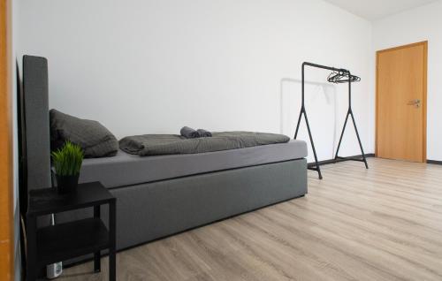 uma sala de estar com uma cama e um piso de madeira em Work & Stay Apartment Bedburg Hau em Hau