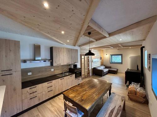 eine Küche mit einem Holztisch und ein Wohnzimmer in der Unterkunft Appartamento Chalet Bernardi in Caderzone