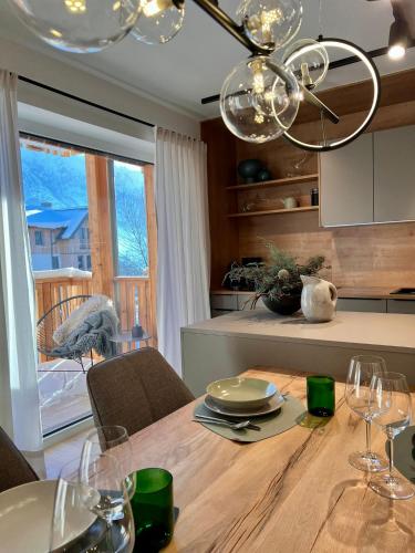 a kitchen with a wooden table with wine glasses at Das Genner - Boutique Appartement in Tauplitz