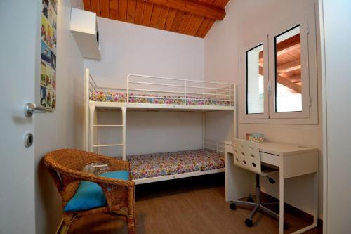 um pequeno quarto com um beliche, uma secretária e uma cadeira. em Casa degli Avi Don Neli, immersa nella natura em Modica