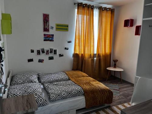 1 dormitorio con 1 cama y una ventana con cortinas en Családbarát lakás Szombathely szívében, en Szombathely