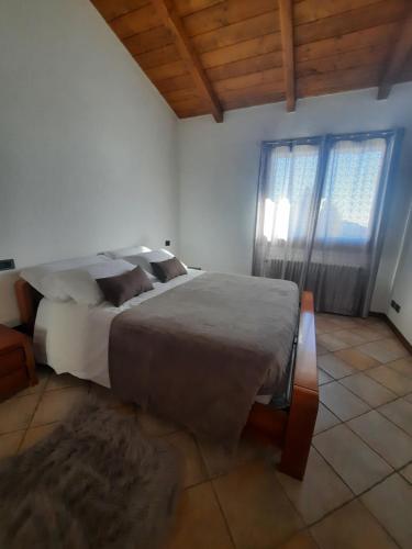 ein Schlafzimmer mit einem großen Bett und einem Fenster in der Unterkunft Villa Duno a un passo da Città Alta in Clanezzo