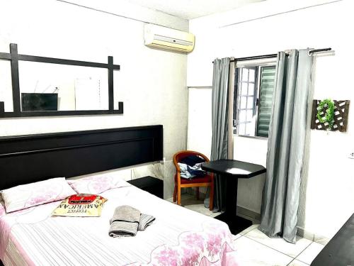 - une chambre avec un lit, une table et une fenêtre dans l'établissement Studio acolhedor em região central de Foz, à Foz do Iguaçu