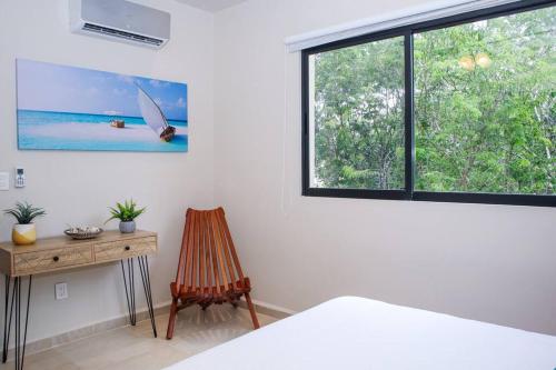 a bedroom with a window and a desk and a chair at New Modern Condo in Playa del Carmen in Playa del Carmen