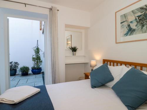 a bedroom with a bed and a glass door at The Old Stores Annexe in Lyme Regis